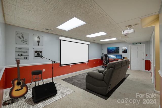 home theater room featuring carpet floors and a paneled ceiling