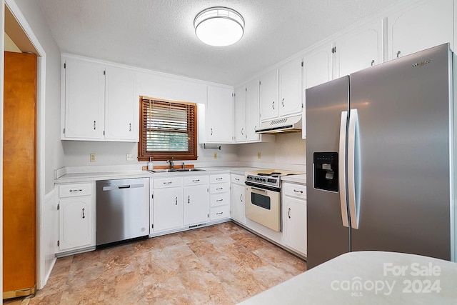 kitchen featuring a textured ceiling, appliances with stainless steel finishes, sink, and white cabinetry