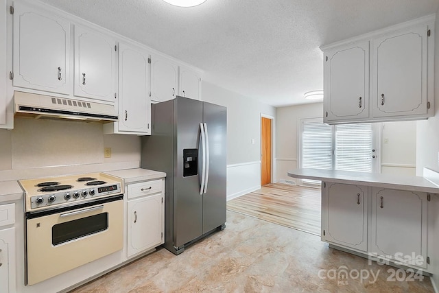 kitchen featuring stainless steel fridge, white cabinetry, white range with electric cooktop, and a textured ceiling