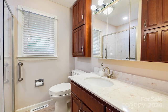 bathroom with a textured ceiling, an enclosed shower, vanity, and toilet