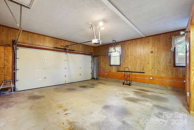 garage with wood walls and a garage door opener