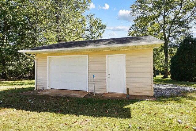 garage featuring a yard and wooden walls