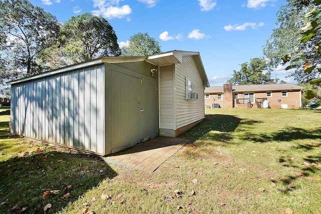 view of outbuilding with cooling unit and a yard