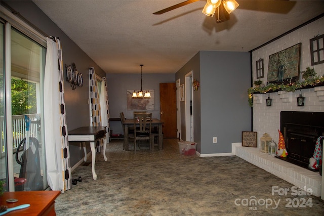 carpeted dining area featuring a textured ceiling, ceiling fan with notable chandelier, and a fireplace