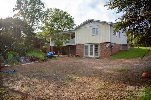 back of property featuring french doors, a balcony, and central air condition unit