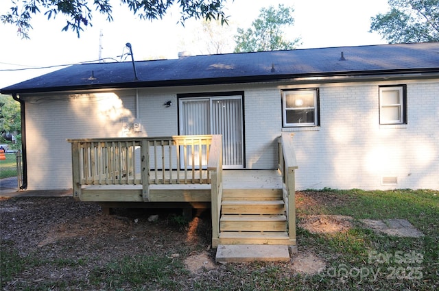 rear view of property featuring a wooden deck
