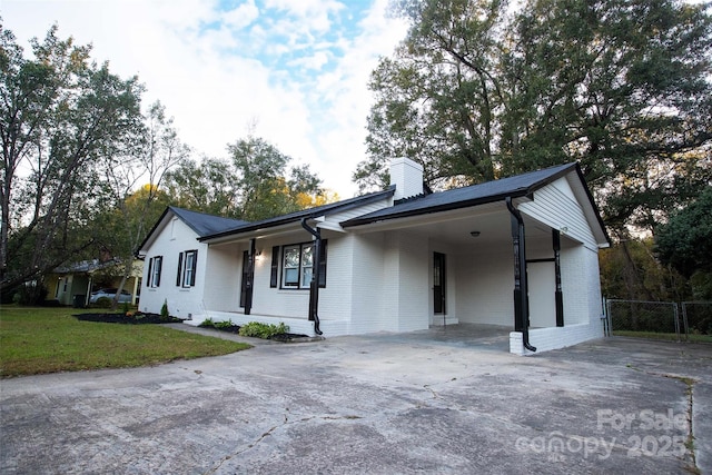 ranch-style home featuring a carport and a front yard