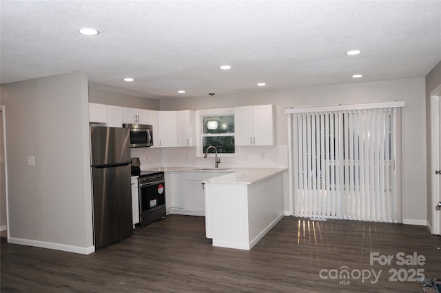 kitchen featuring dark wood-type flooring, white cabinets, sink, light stone countertops, and appliances with stainless steel finishes