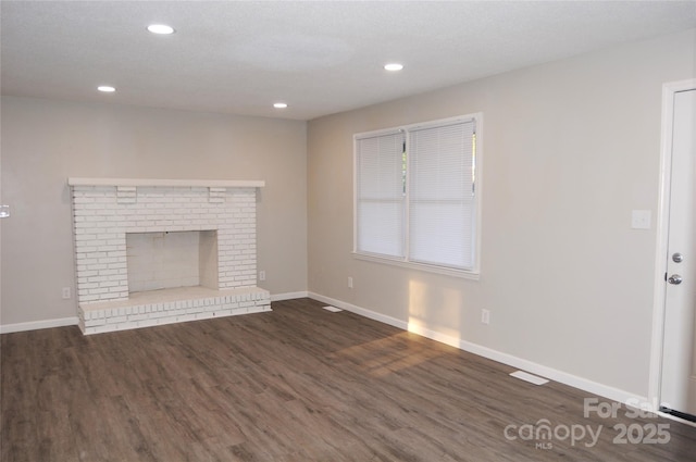 unfurnished living room with a fireplace and dark hardwood / wood-style floors