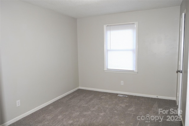 unfurnished room featuring dark carpet