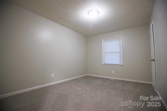 carpeted spare room featuring a textured ceiling