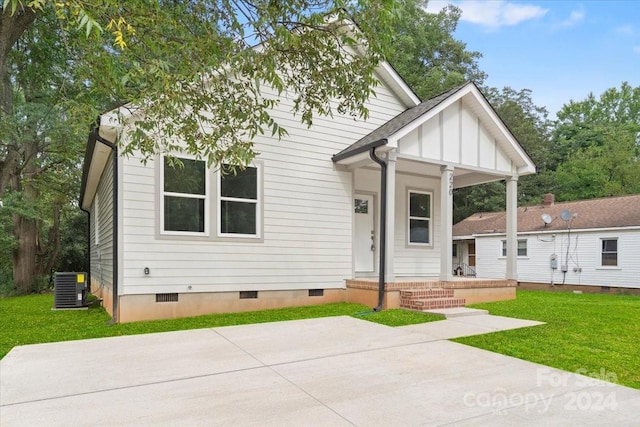 view of front of house featuring central AC unit and a front yard