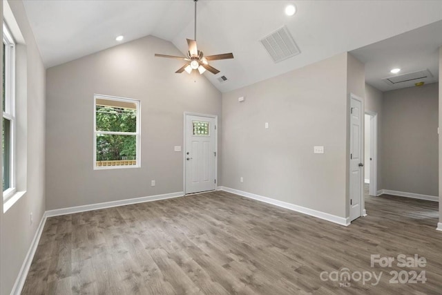 empty room featuring hardwood / wood-style flooring, high vaulted ceiling, and ceiling fan