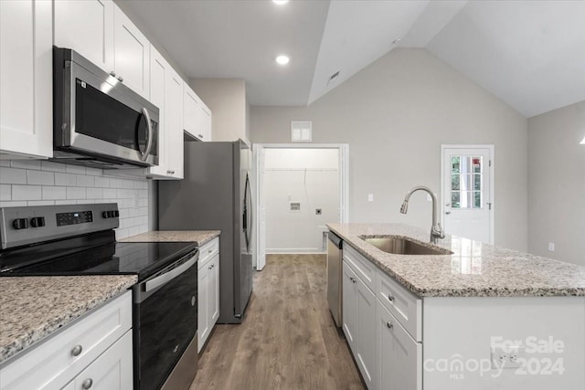 kitchen with an island with sink, sink, wood-type flooring, white cabinetry, and stainless steel appliances