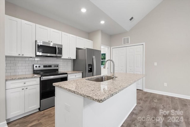 kitchen with white cabinets, a center island with sink, appliances with stainless steel finishes, and sink