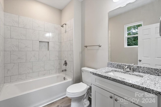 full bathroom featuring hardwood / wood-style flooring, toilet, vanity, and tiled shower / bath