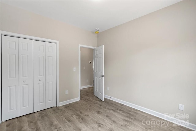 unfurnished bedroom featuring light wood-type flooring and a closet