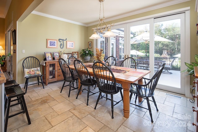 dining area with ornamental molding and a chandelier