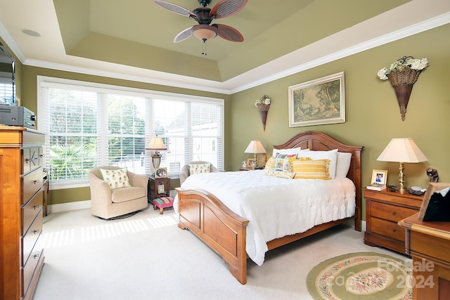 bedroom featuring carpet, crown molding, a raised ceiling, and ceiling fan