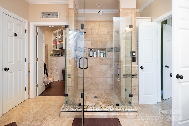 bathroom with hardwood / wood-style floors, crown molding, and a shower with shower door