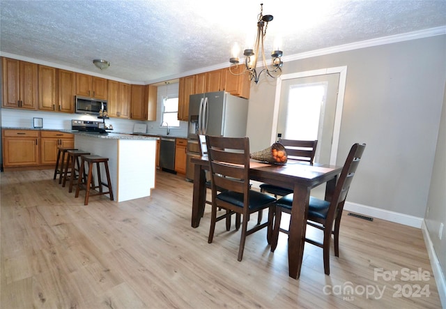 dining space with ornamental molding, a notable chandelier, and light wood-type flooring