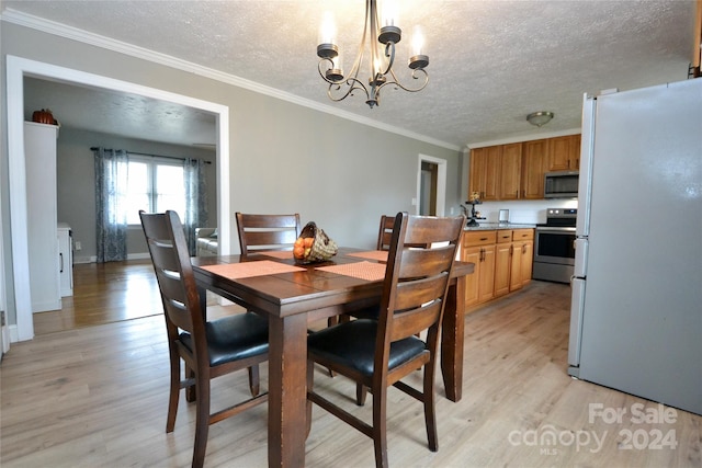 dining space featuring an inviting chandelier, ornamental molding, a textured ceiling, and light wood-type flooring