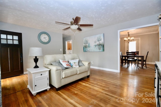 living room featuring a textured ceiling, light hardwood / wood-style flooring, and ceiling fan with notable chandelier