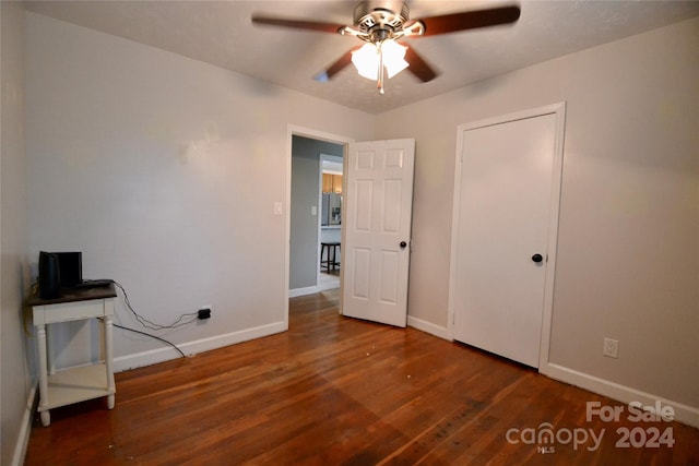 unfurnished bedroom featuring dark hardwood / wood-style floors and ceiling fan