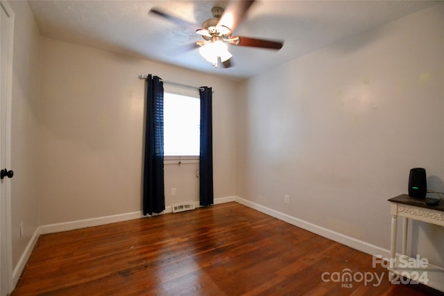 unfurnished room with dark wood-type flooring and ceiling fan