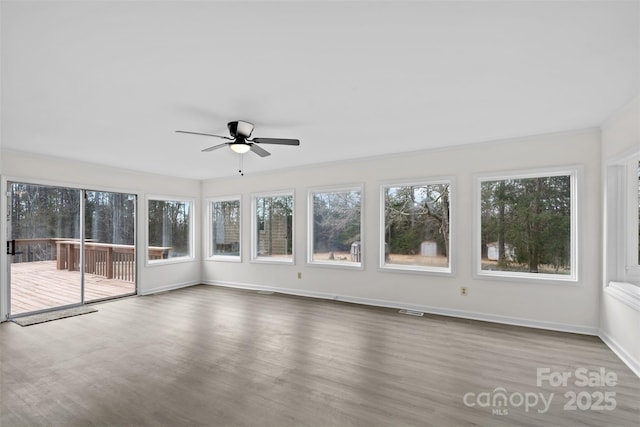 unfurnished sunroom featuring visible vents and a ceiling fan