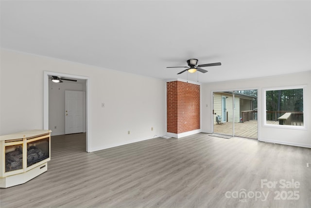 unfurnished living room featuring ornamental molding, a ceiling fan, baseboards, and wood finished floors