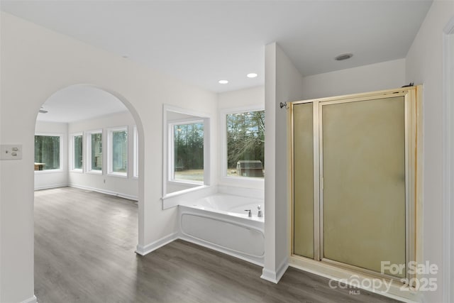 full bath with baseboards, a garden tub, wood finished floors, and a shower stall