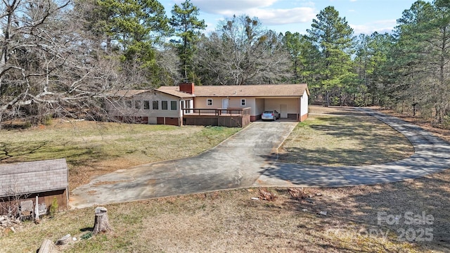 single story home featuring concrete driveway and a front yard