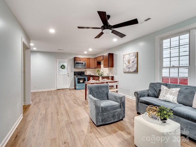 living room with light wood-type flooring and ceiling fan