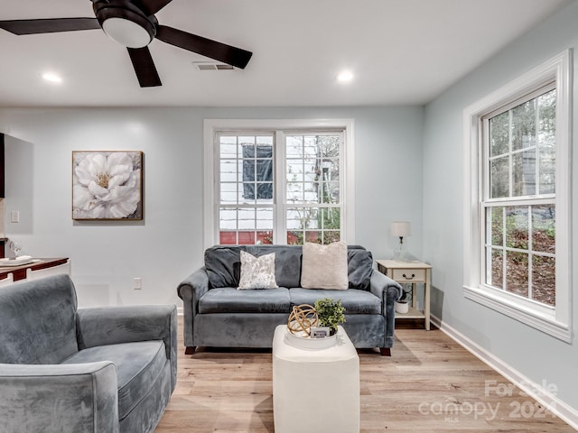 living room featuring a wealth of natural light, ceiling fan, and light hardwood / wood-style floors