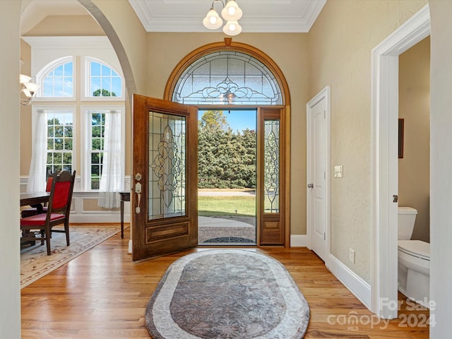 foyer entrance featuring ornamental molding, a chandelier, and light hardwood / wood-style flooring