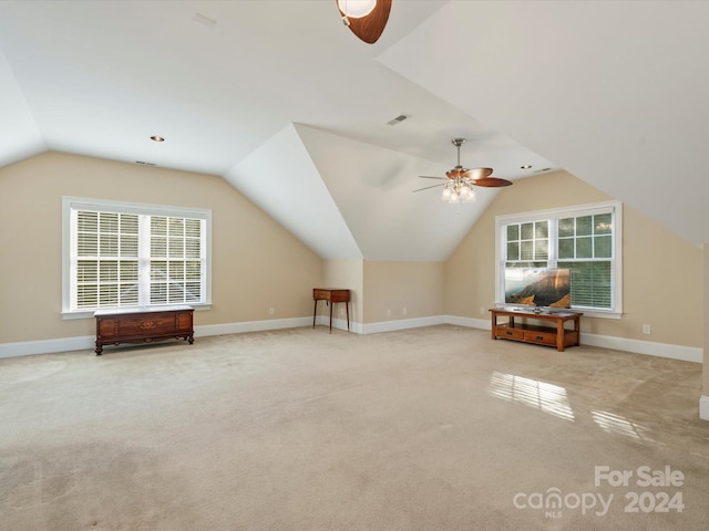 additional living space with a wealth of natural light, lofted ceiling, light colored carpet, and ceiling fan