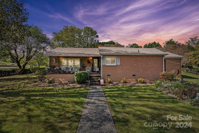 ranch-style home with a yard and a porch