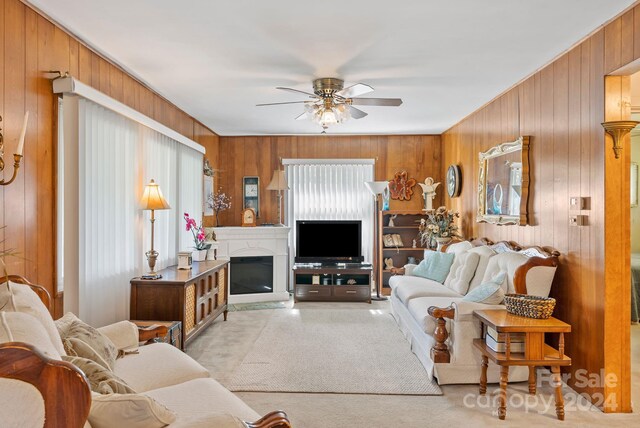 living room featuring wood walls and ceiling fan