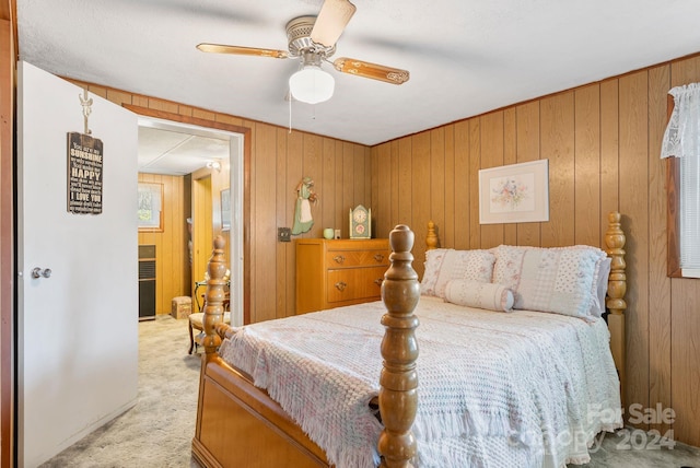 carpeted bedroom with wooden walls and ceiling fan