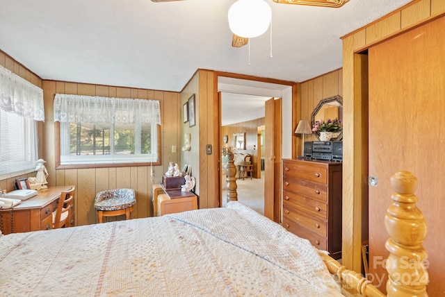 bedroom featuring carpet floors, ceiling fan, and wood walls