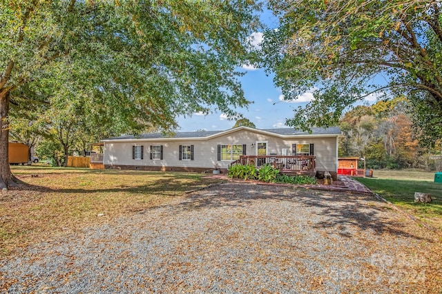 ranch-style house with a front yard and a wooden deck