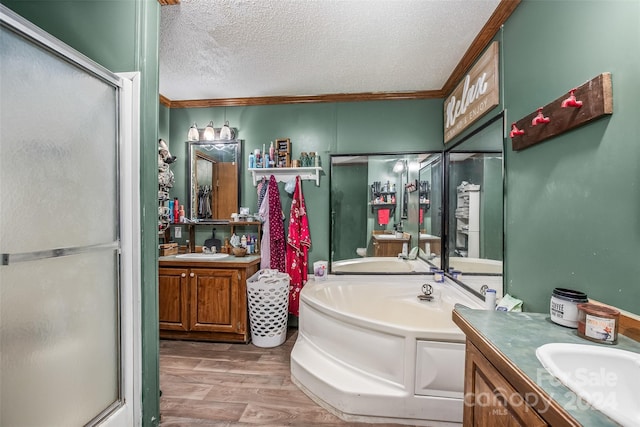 bathroom featuring wood-type flooring, ornamental molding, vanity, shower with separate bathtub, and a textured ceiling