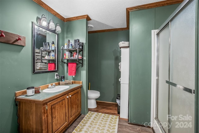 bathroom with hardwood / wood-style flooring, toilet, vanity, a textured ceiling, and an enclosed shower