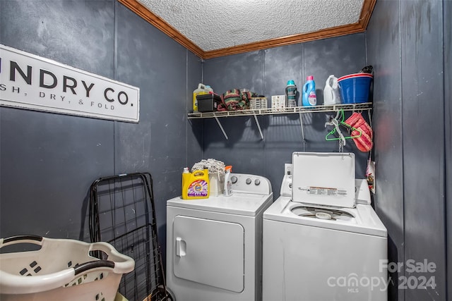 laundry area featuring independent washer and dryer, ornamental molding, and a textured ceiling