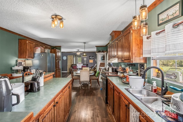 kitchen featuring sink, stainless steel appliances, pendant lighting, dark wood-type flooring, and crown molding