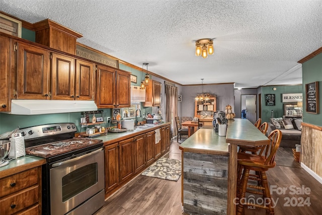 kitchen with dark hardwood / wood-style flooring, a textured ceiling, stainless steel range with electric stovetop, crown molding, and decorative light fixtures