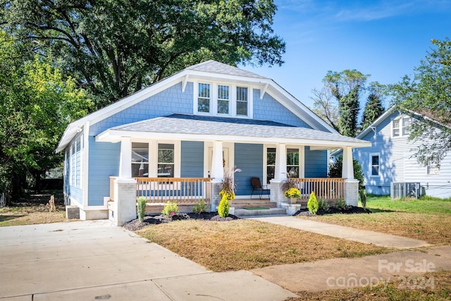 bungalow-style house with a front yard and covered porch