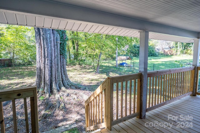 wooden terrace featuring a yard