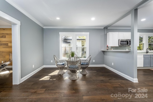 dining room with plenty of natural light, crown molding, dark hardwood / wood-style flooring, and sink